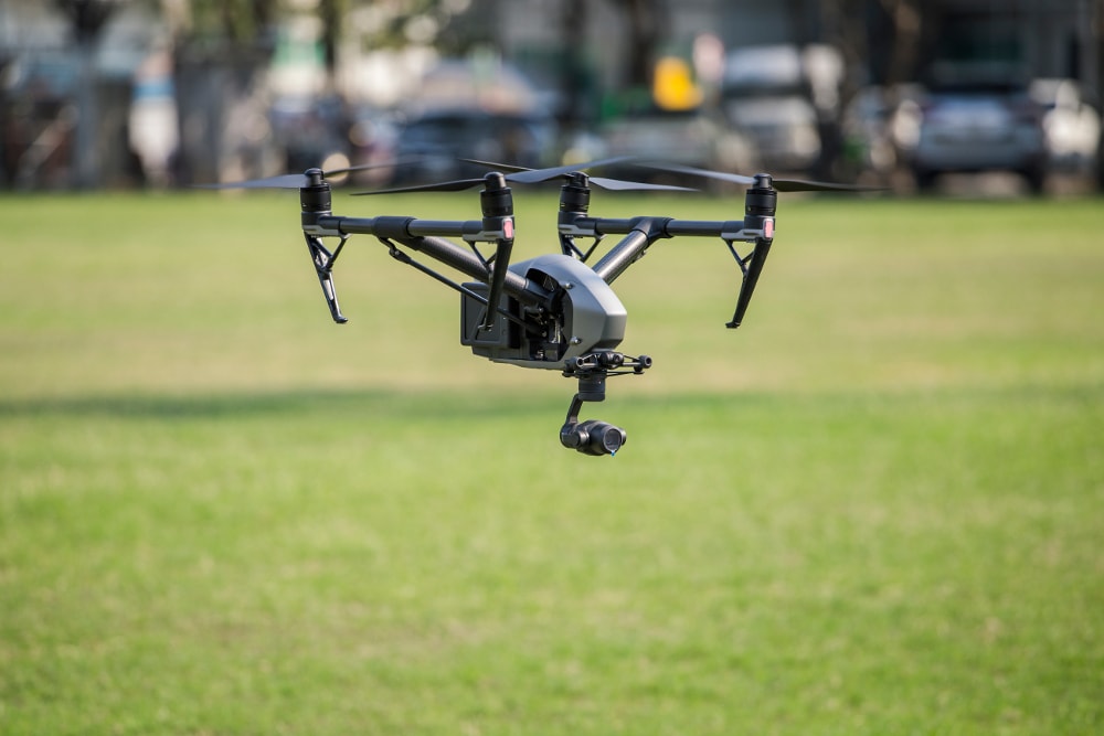 Drone flying low to the ground in field whilst taking pictures