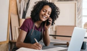 A woman access embedded finance through a phone call and makes notes