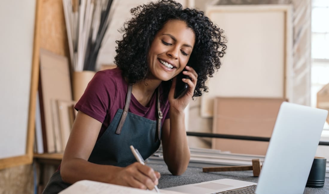 A woman access embedded finance through a phone call and makes notes