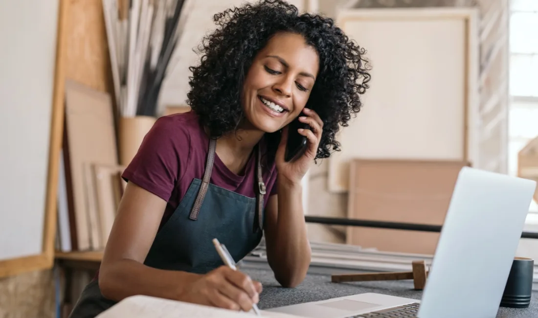 A woman access embedded finance through a phone call and makes notes