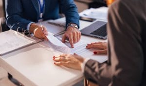 Two professionals reviewing financial documents at a desk, highlighting financial protection and business insurance.