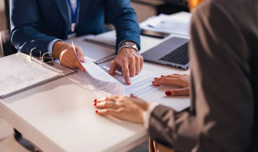 Two professionals reviewing financial documents at a desk, highlighting financial protection and business insurance.