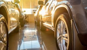 Two cars parked parallel to one another in a car showroom