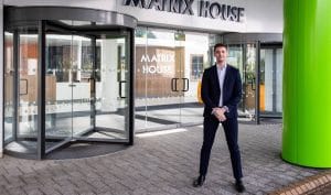 Bluestar's Jake standing outside Matrix House office building, celebrating a strong start to year two.