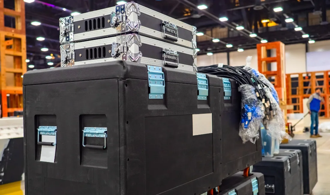 Stacked flight cases and coiled cables in a warehouse or event setup environment, representing event production equipment