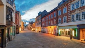 A row of retail shops in a Victorian high street at sundown