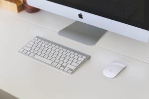 Close up view of an imac sitting on a white, wooden desk