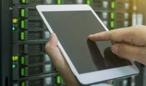 A man configuring settings using an iPad within the server room
